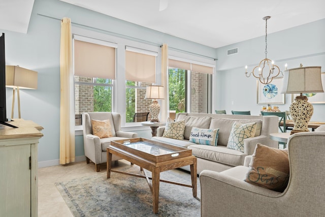 tiled living room with a notable chandelier