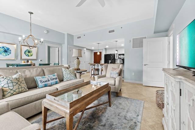 tiled living room with ceiling fan with notable chandelier