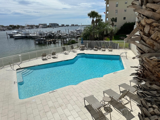 view of pool with a water view and a patio