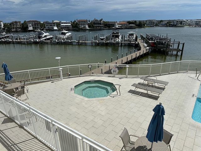 view of swimming pool with a water view, a boat dock, a hot tub, and a patio area