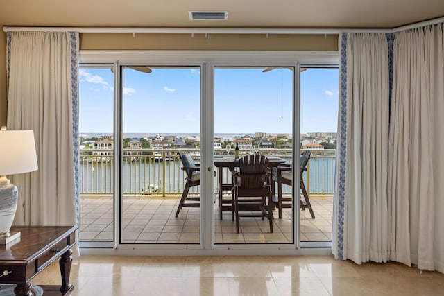 doorway with a water view and light tile patterned floors