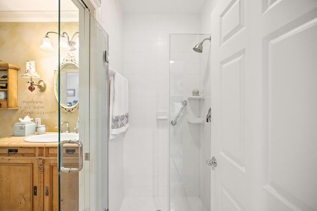 bathroom featuring walk in shower, ornamental molding, and vanity