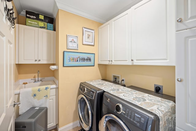 clothes washing area featuring sink, cabinets, washer and clothes dryer, and ornamental molding