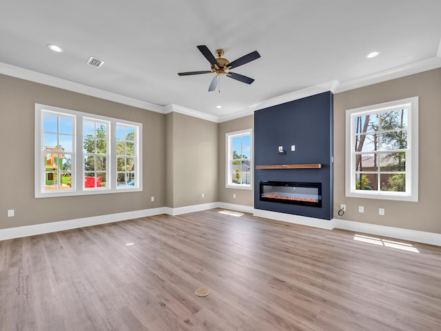 unfurnished living room with a large fireplace, plenty of natural light, and baseboards