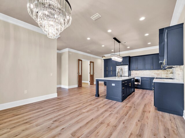 kitchen featuring a kitchen bar, a center island with sink, hanging light fixtures, and light hardwood / wood-style floors