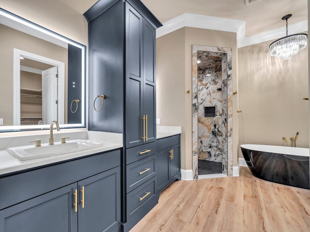 bathroom featuring vanity, shower with separate bathtub, an inviting chandelier, and hardwood / wood-style flooring