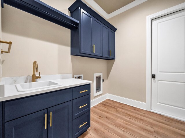 washroom with cabinets, electric dryer hookup, sink, ornamental molding, and light hardwood / wood-style flooring