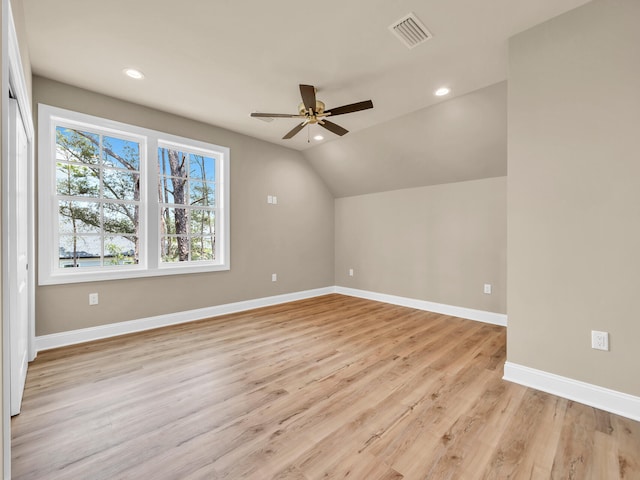 additional living space featuring lofted ceiling, a ceiling fan, light wood-style floors, visible vents, and baseboards