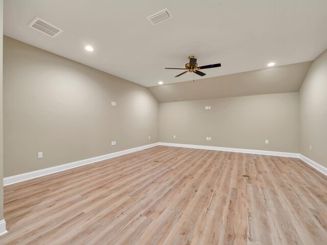 empty room with light hardwood / wood-style flooring, lofted ceiling, and ceiling fan