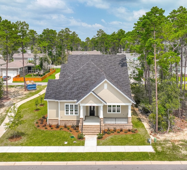 craftsman house featuring covered porch and a front yard