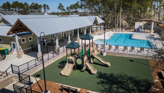 community play area with a patio area, a community pool, and fence