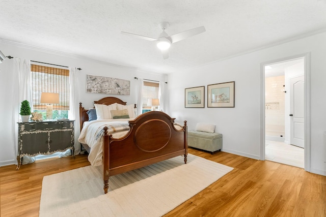 bedroom featuring light hardwood / wood-style flooring, ensuite bath, a textured ceiling, and ceiling fan