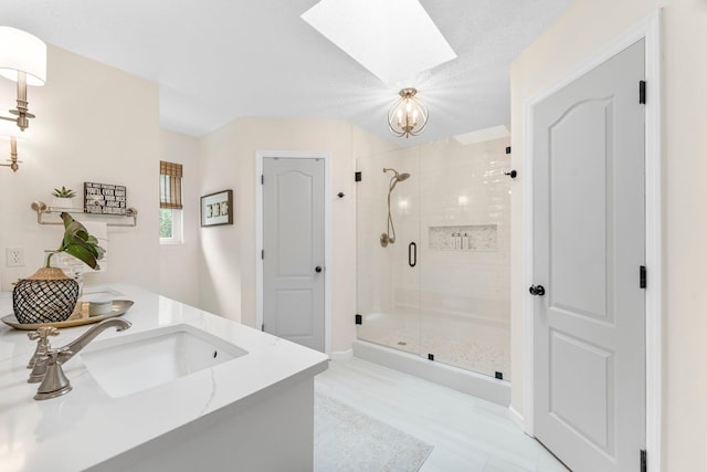 bathroom with a skylight, a shower with door, and vanity