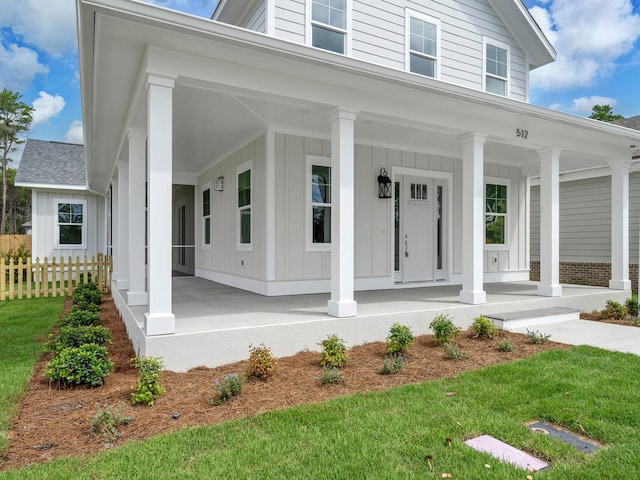 view of front of property featuring covered porch, fence, and board and batten siding