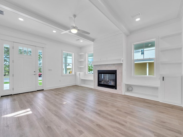 unfurnished living room featuring built in features, beamed ceiling, light hardwood / wood-style flooring, a tile fireplace, and ceiling fan