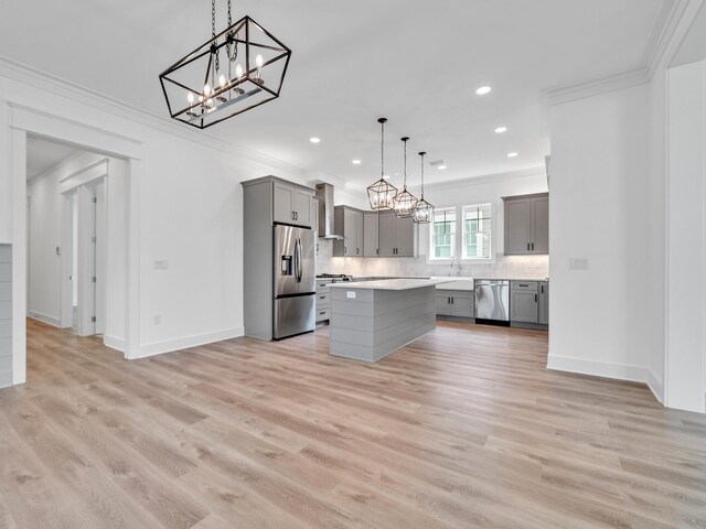 kitchen featuring tasteful backsplash, a kitchen island, appliances with stainless steel finishes, light hardwood / wood-style flooring, and gray cabinetry