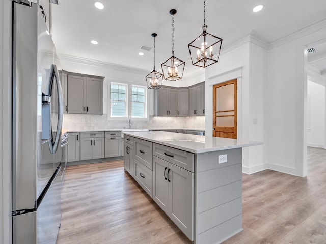 kitchen with a kitchen island, light hardwood / wood-style flooring, backsplash, and stainless steel fridge with ice dispenser