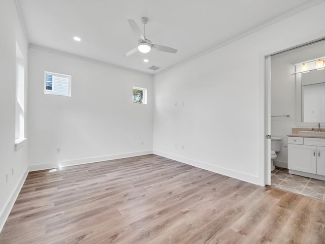 interior space featuring light hardwood / wood-style flooring, connected bathroom, ceiling fan, and crown molding