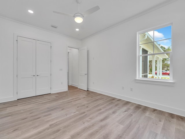 unfurnished bedroom featuring light wood-type flooring, ceiling fan, ornamental molding, and a closet