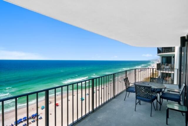 balcony with a water view and a beach view