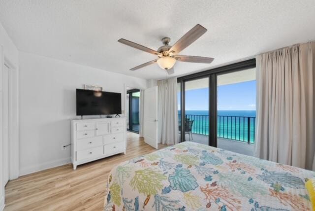 bedroom with a water view, access to outside, ceiling fan, and light hardwood / wood-style floors