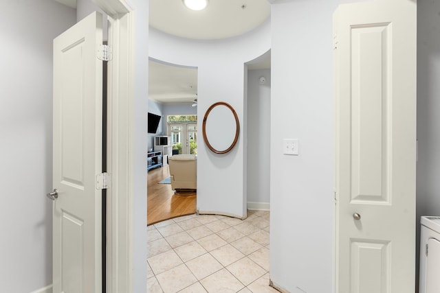 hallway featuring washer / clothes dryer and light tile patterned flooring