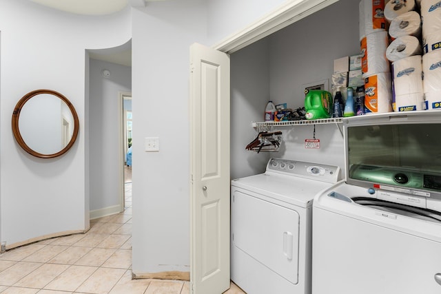 laundry area featuring light tile patterned floors and washing machine and clothes dryer