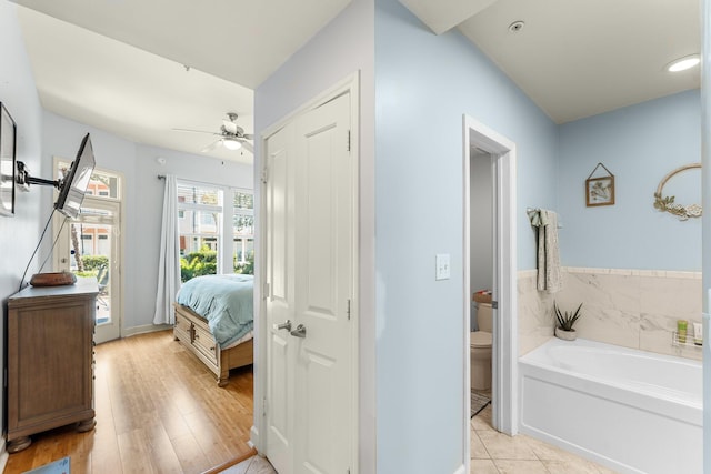 bathroom featuring tile patterned flooring, toilet, a bathtub, and ceiling fan