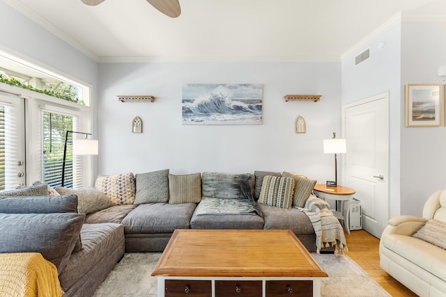 living room with light hardwood / wood-style flooring, ceiling fan, and crown molding