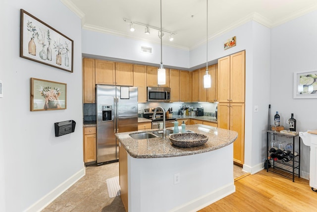 kitchen featuring stone counters, sink, hanging light fixtures, a center island with sink, and appliances with stainless steel finishes