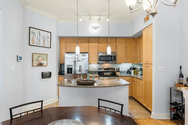 kitchen with crown molding, an island with sink, a chandelier, pendant lighting, and appliances with stainless steel finishes