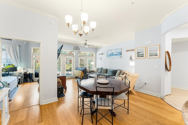 dining room with ceiling fan with notable chandelier, light hardwood / wood-style floors, and ornamental molding