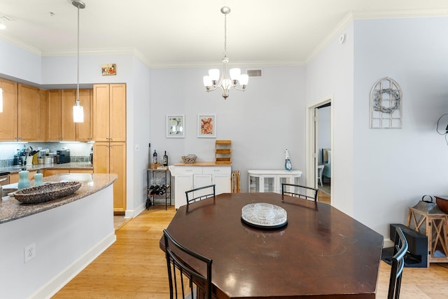 dining room featuring an inviting chandelier, light wood-type flooring, and ornamental molding