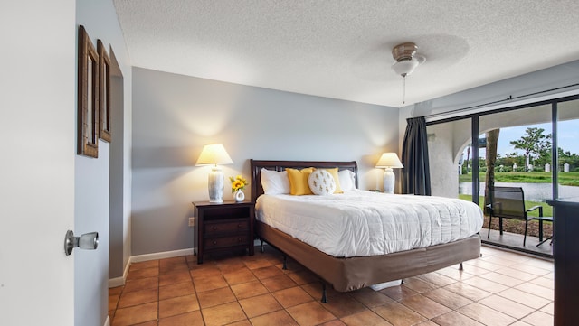 bedroom featuring access to exterior, tile patterned flooring, ceiling fan, and a textured ceiling