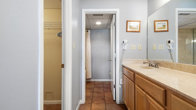 bathroom featuring vanity, tile patterned flooring, toilet, and a drop ceiling