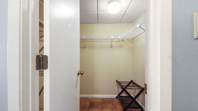 spacious closet with tile patterned flooring and a drop ceiling