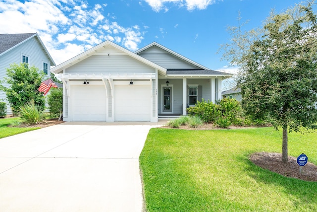 view of front of home with covered porch, a garage, and a front lawn