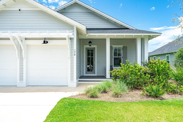 view of front facade featuring covered porch, a garage, and a front lawn