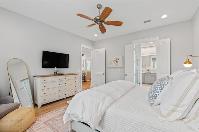 bedroom featuring ceiling fan, light hardwood / wood-style floors, and ensuite bathroom