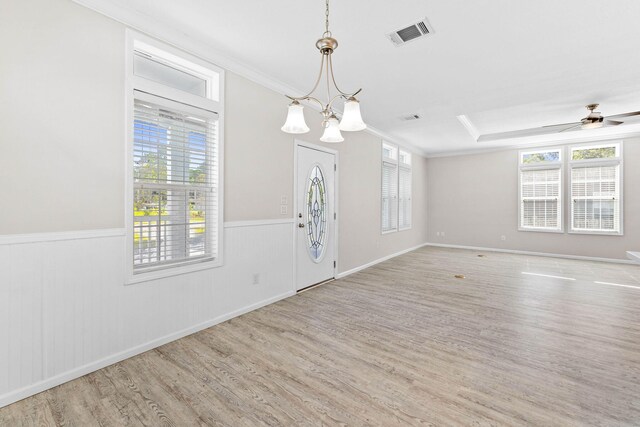 foyer featuring crown molding, ceiling fan with notable chandelier, light hardwood / wood-style floors, and a tray ceiling