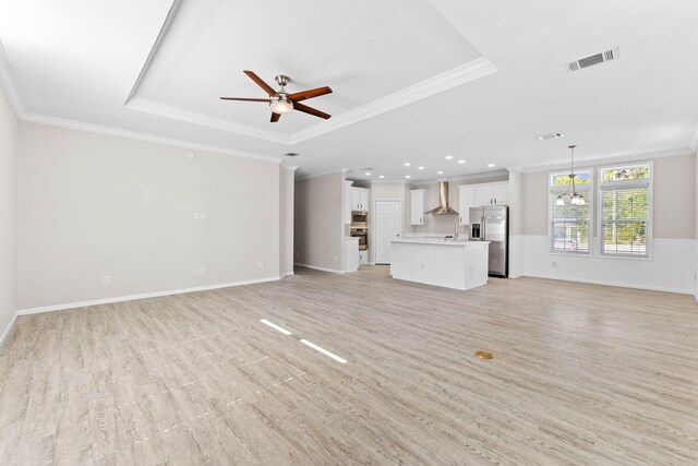 unfurnished living room featuring ceiling fan with notable chandelier, ornamental molding, and light hardwood / wood-style floors