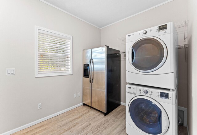 laundry room featuring crown molding, stacked washing maching and dryer, and light wood-type flooring