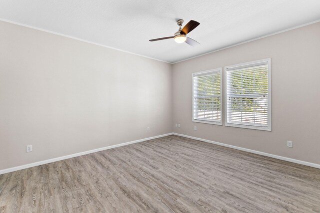 empty room with hardwood / wood-style flooring, ceiling fan, ornamental molding, and a textured ceiling