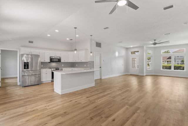 kitchen featuring appliances with stainless steel finishes, pendant lighting, white cabinetry, backsplash, and light hardwood / wood-style floors