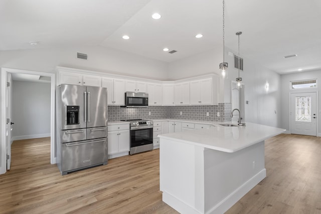 kitchen with sink, white cabinetry, decorative light fixtures, appliances with stainless steel finishes, and kitchen peninsula