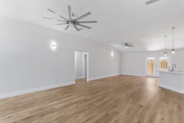 unfurnished living room featuring sink, vaulted ceiling, light hardwood / wood-style floors, and ceiling fan