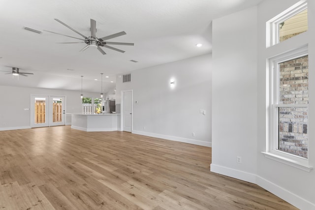 unfurnished living room with french doors, ceiling fan, and light hardwood / wood-style flooring