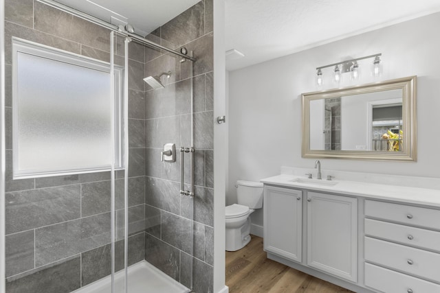 bathroom featuring vanity, an enclosed shower, hardwood / wood-style flooring, and toilet