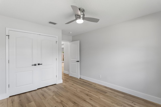 unfurnished bedroom with light hardwood / wood-style flooring, a closet, and ceiling fan