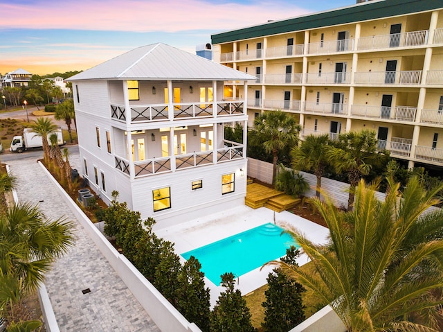 pool at dusk featuring central AC